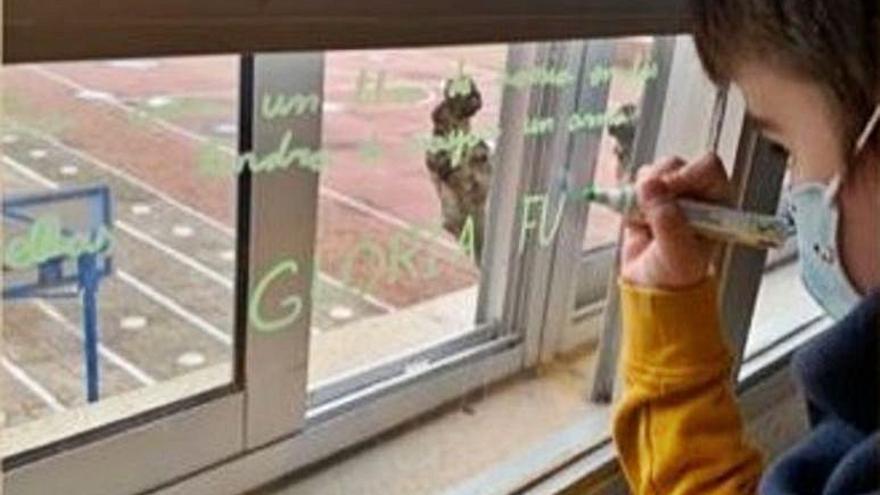 Un niño decora una ventana del Hospital de la Cruz. | Cedida