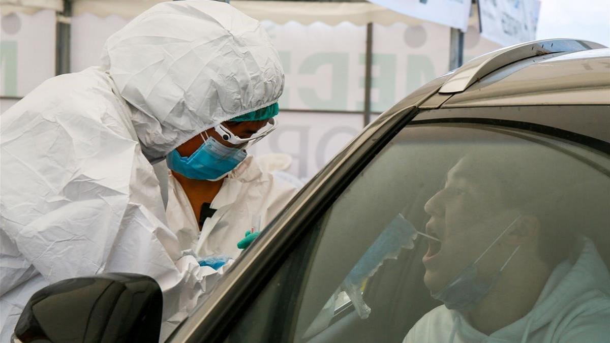 Un trabajador sanitario toma muestras de un ciudadano para realizarle la prueba de covid en Almatý, en Kazajistán, el 5 de julio del 2020