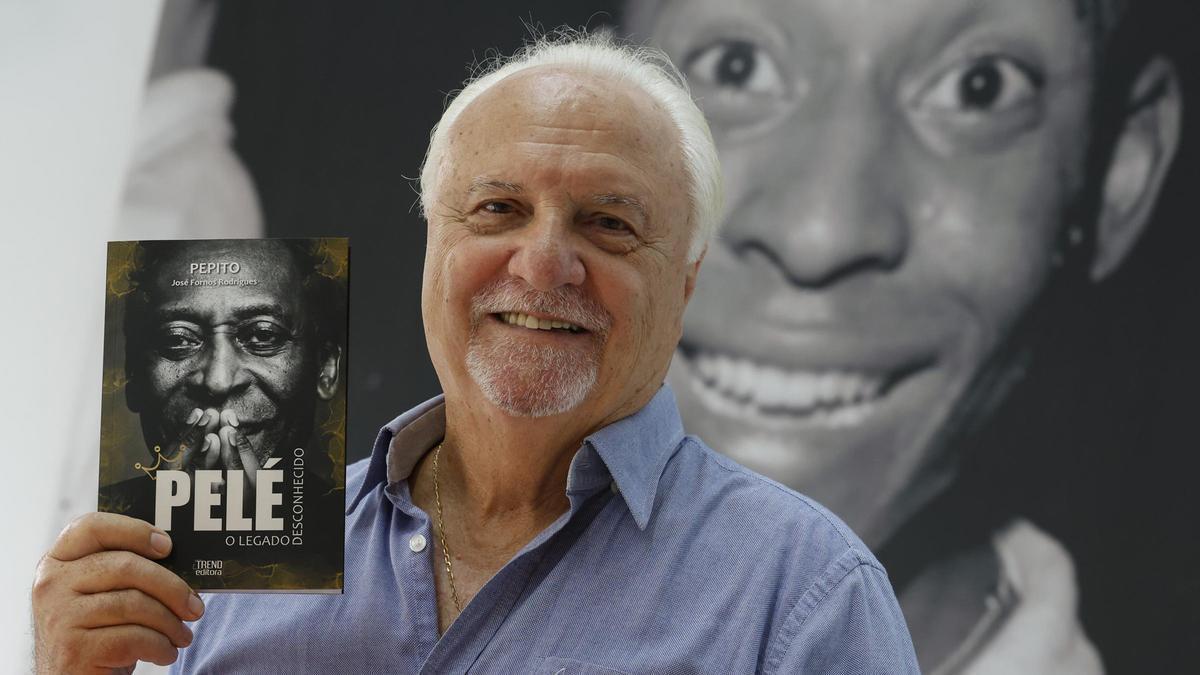 Pepito, exagente de Pelé, con un ejemplar del libro dedicado al mito brasileño.