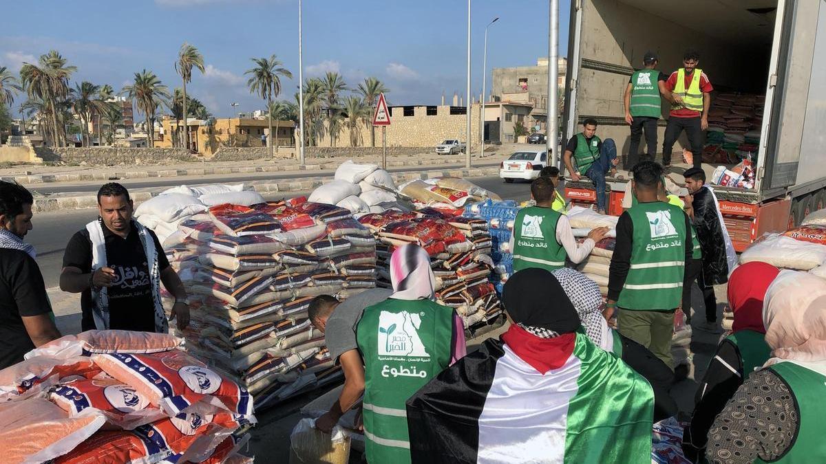 Un grupo de voluntarios carga un camión con ayuda humanitaria en Arish, Egipto, para ser trasladada a Gaza.