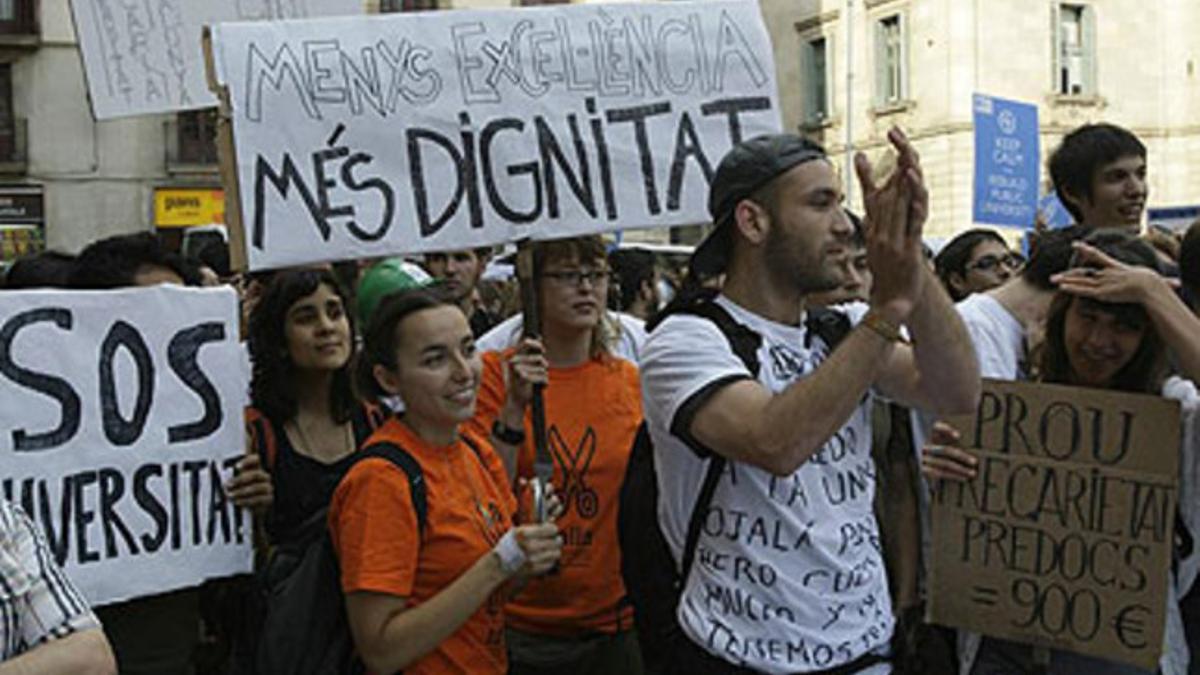 Un grupo de jóvenes lanzan consignas contra los recortes presupuestarios en la plaza Sant Jaume