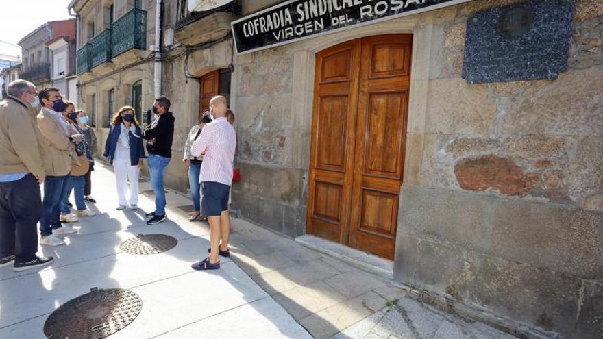 Representantes de la cofradía y la Xunta ante el pósito de Vilaxoán.