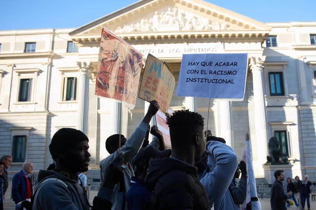 Un grupo de personas migrantes se manifiestan en el Congreso de los Diputados durante la toma en consideración de la ILP de regularización extraordinaria en Madrid.