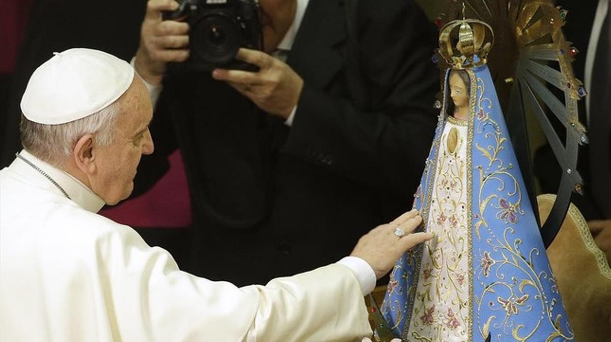 El papa Francesc toca una estàtua de la Mare de Déu durant una cerimònia al Vaticà aquest dijous.