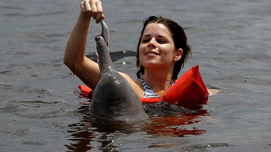 La actriz canadiense Neve Campbell juega con un delfín rosado o Boto en el río Ariaú, municipio de Iranduba, a 65 kilómetros de Manaos (Brasil), en el marco de la quinta edición del Festival de Cine del Amazonas.