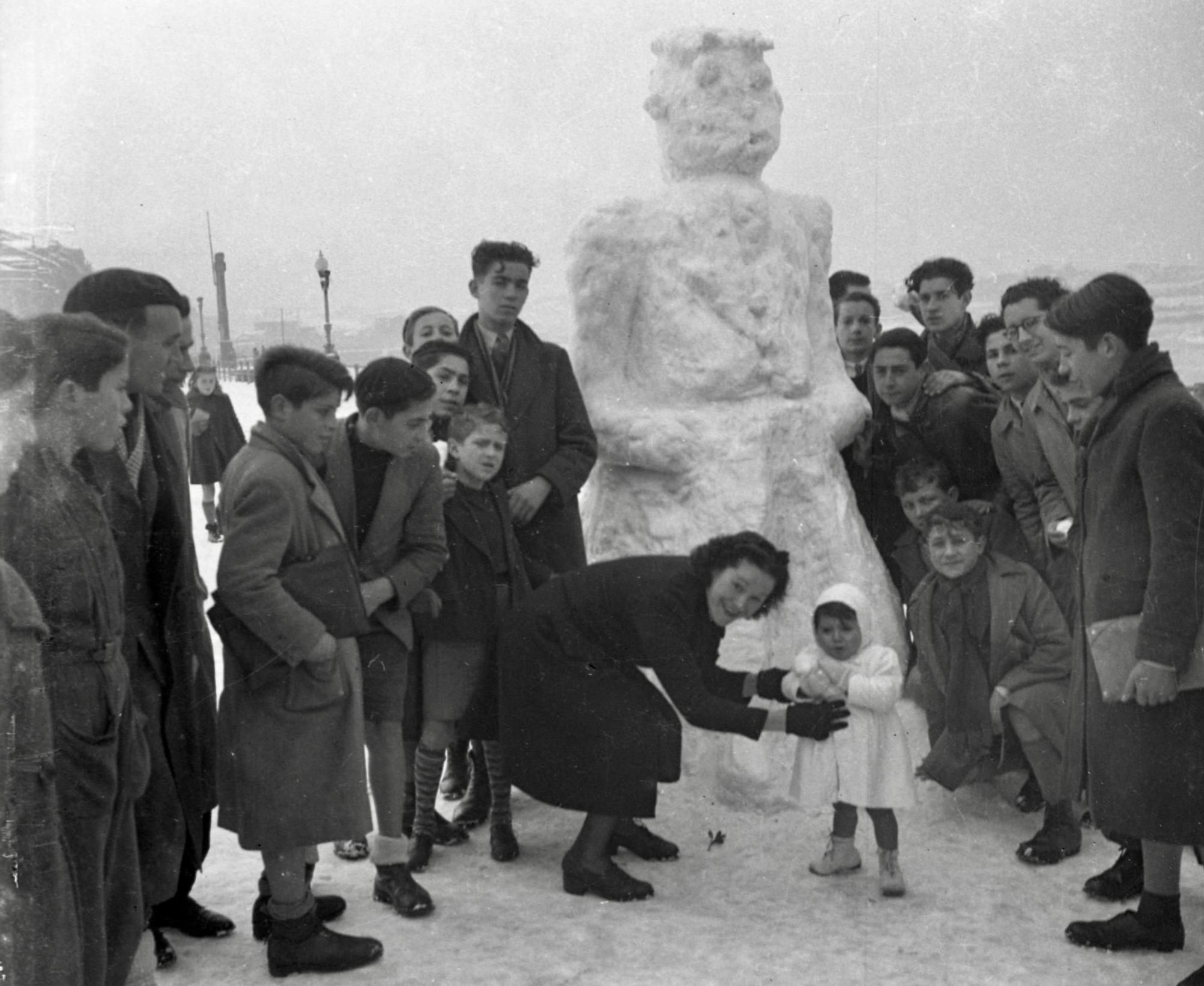 Retrato de gijoneses junto a un muñeco de nieve en el Muro de San Lorenzo. Gijón/Xixón, 24 de febrero de 1944. Col. Muséu del Pueblu d’Asturies