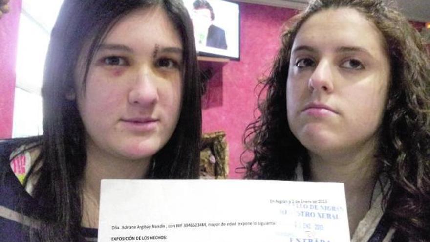 Adriana Argibay, con seis puntos en una ceja, y su amiga Antía González muestran la denuncia.  // N.P.