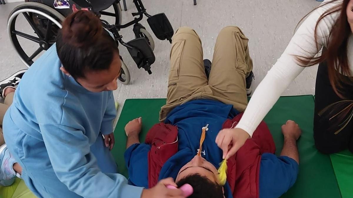 Dos alumnos en el desarrollo de unas prácticas para ayudar a personas con dependencia.