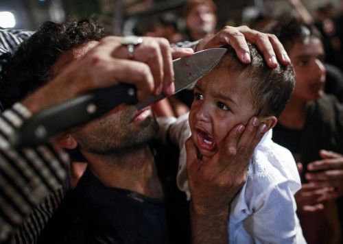 A Shi'ite Muslim has his child gashed with a knife during a Muharram procession ahead of Ashoura in Mumbai