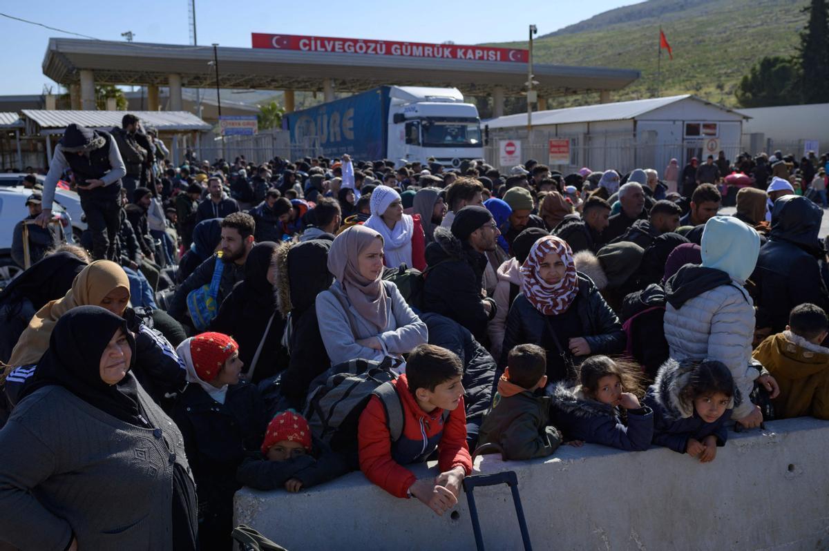 Los residentes sirios de la ciudad de Hatay esperan para cruzar la frontera entre Turquía y Siria después de que se vieron afectados por el terremoto de magnitud 7,8 que asoló la región hace casi dos semanas, en la puerta fronteriza de Cilvegozu