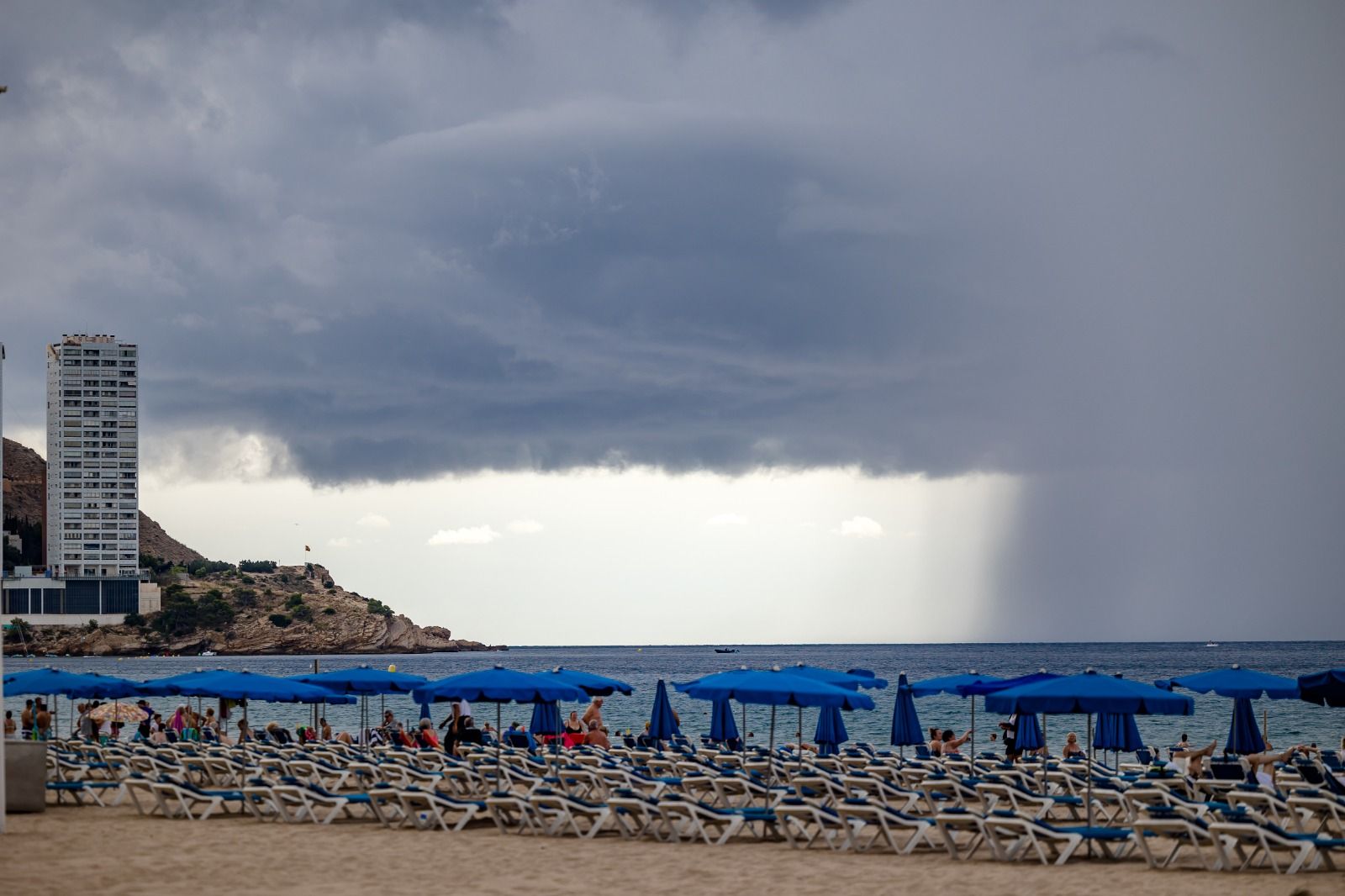 Los bañistas permanecen en las playas de Benidorm pese a la amenaza de lluvias