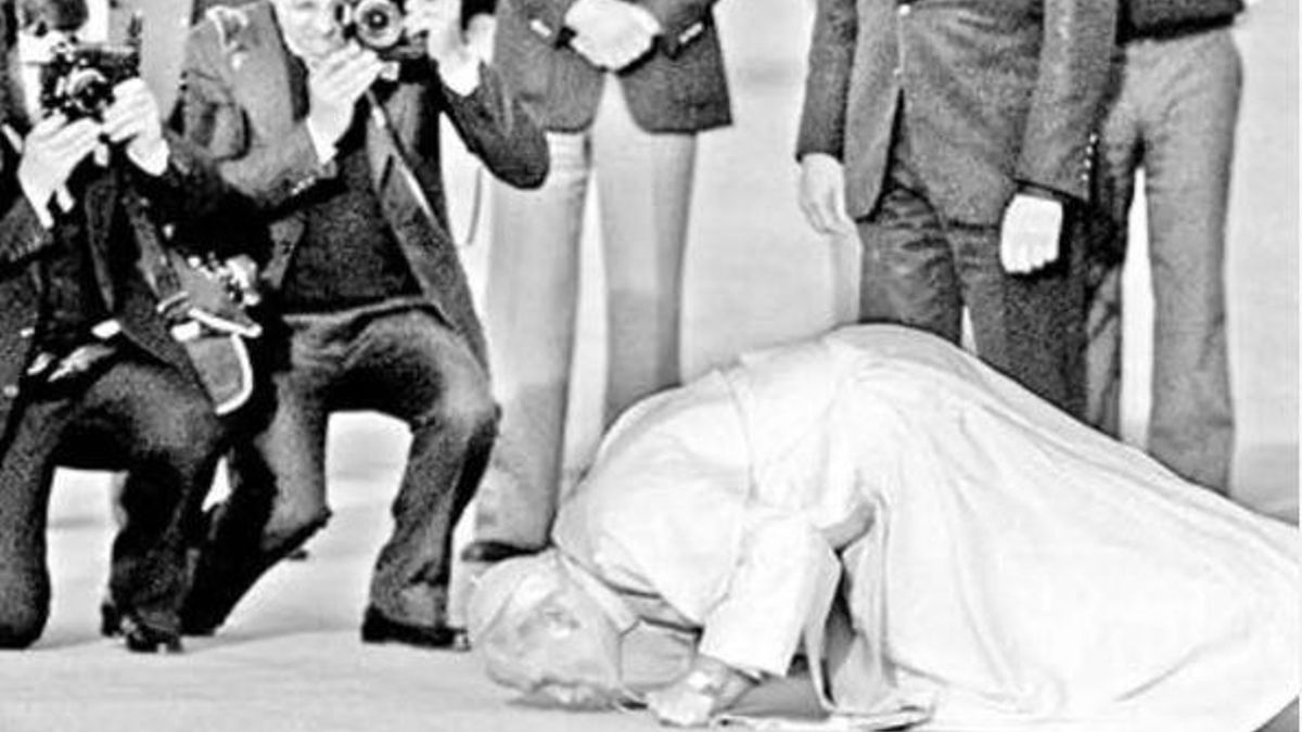 El papa Juan Pablo II besa el suelo tras aterrizar en España en 1982.