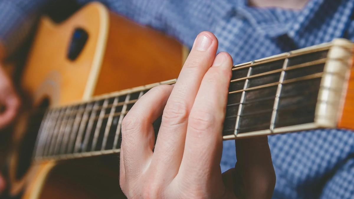 Imagen de una persona tocando la guitarra.