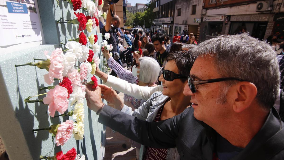 Los asistentes colocan los claveles en homenaje a los deportados.