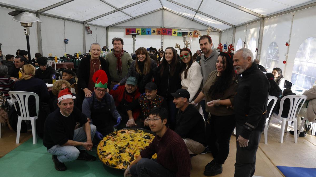 Los voluntarios del Paluso con la paella gigante que se sirvió este lunes en el almuerzo navideño
