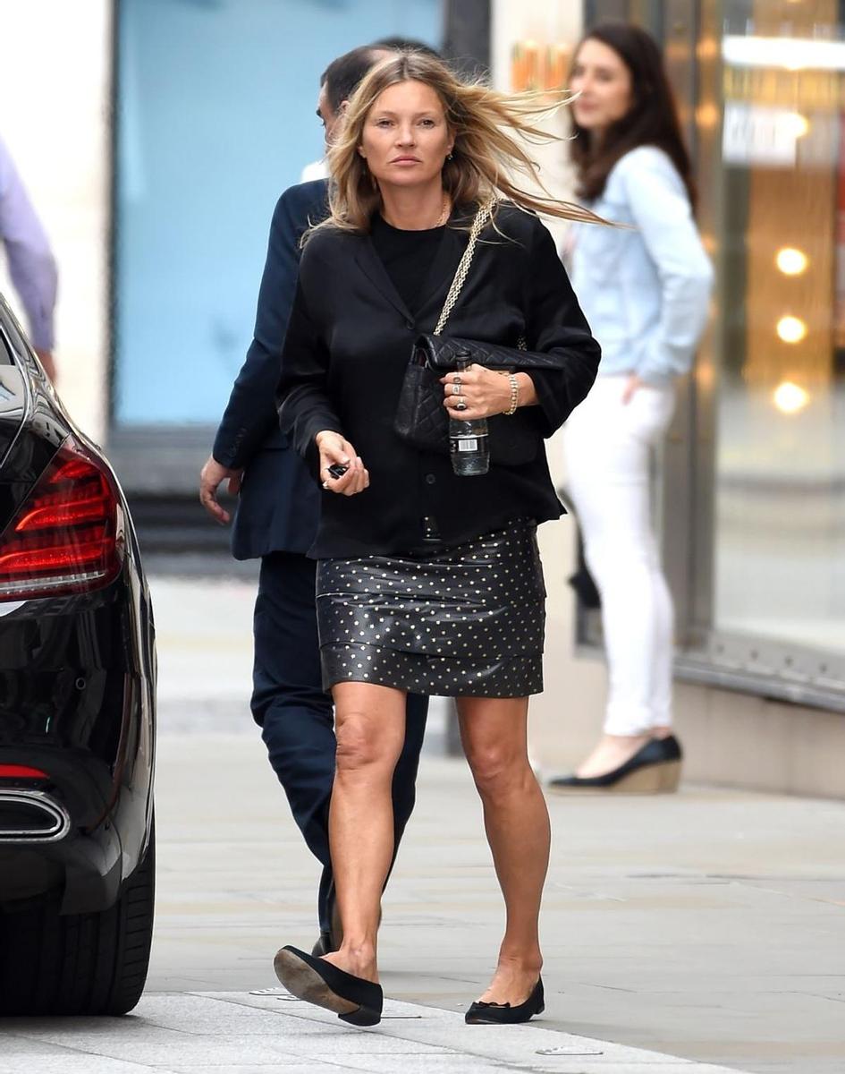 Kate Moss con look en negro compuesto por minifalda y bailarinas