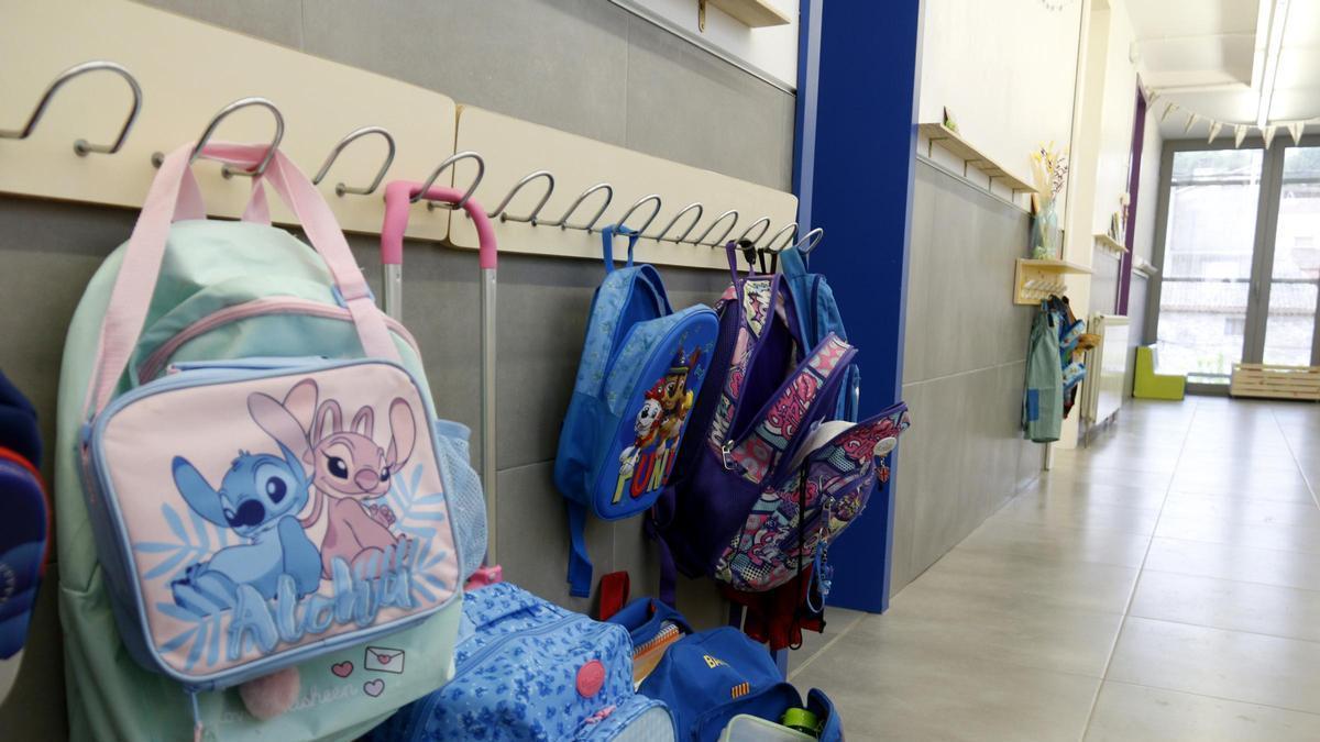 Motxilles penjades al passadís d'una escola.