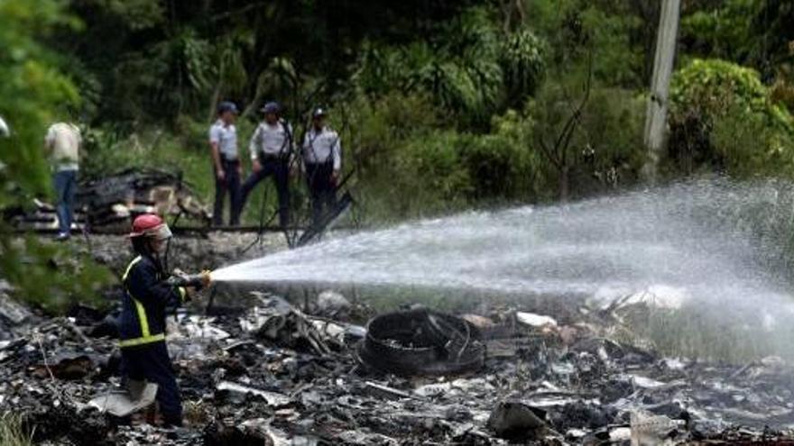 Un bomber treballant per apagar les flames després del fatal accident