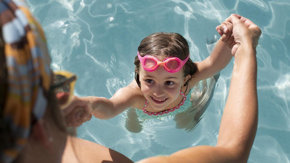 UNA JOVEN JUNTO A UNA PISCINA PORTATIL