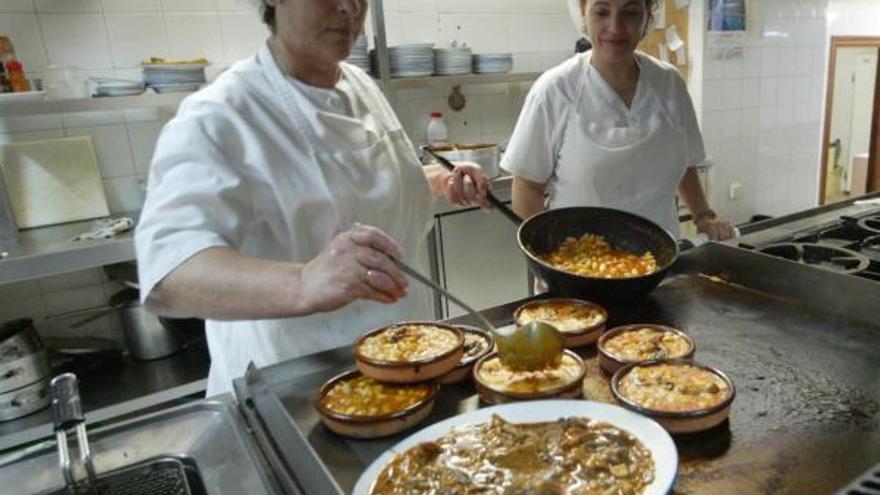 Dos cocineras preparan un plato de setas.