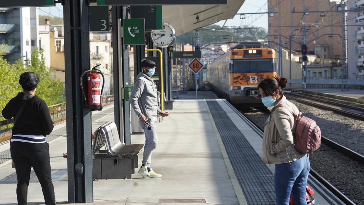 Tres persones amb mascareta a l’estació de tren de Girona en una fotografia d’arxiu. | MARC MARTÍ