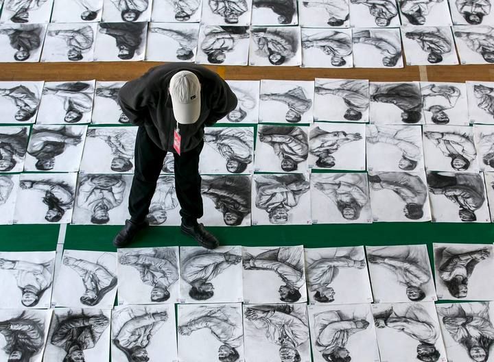 Un profesor observa los bocetos realizados por los candidatos de la Academia China de Arte