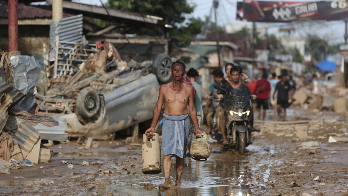 Un superviviente camina por una de las zonas afectada por las inundaciones en la isla de Sumatra, Indonesia.