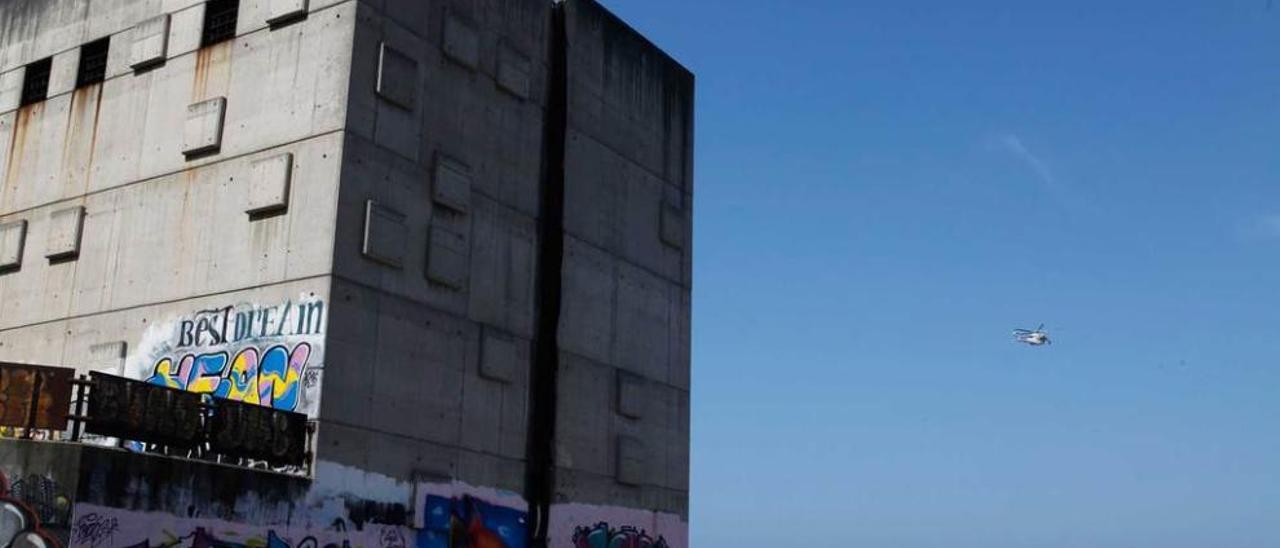 El edificio del emisario de Peñarrubia, con el &quot;Helimer&quot; al fondo sobrevolando la zona.