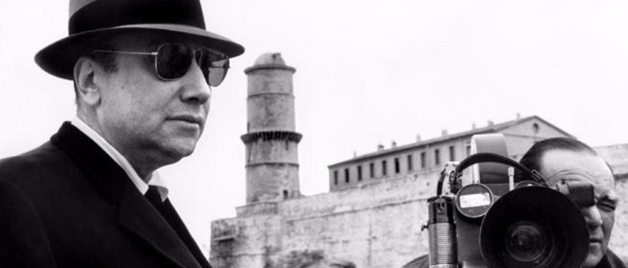 Jean-Pierre Melville, en primer plano, durante el rodaje de una película.