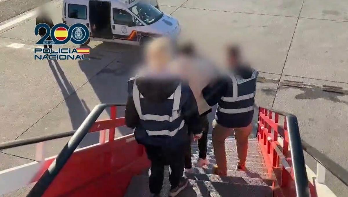 Agentes de la Policía, con el acusado a su llegada a España.