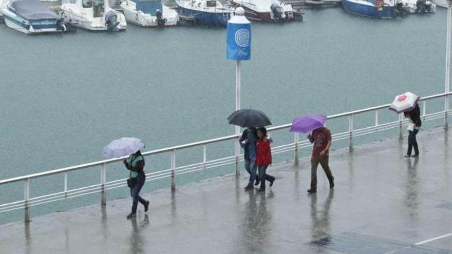 Paseantes durante una tormenta caída a principios de agosto.