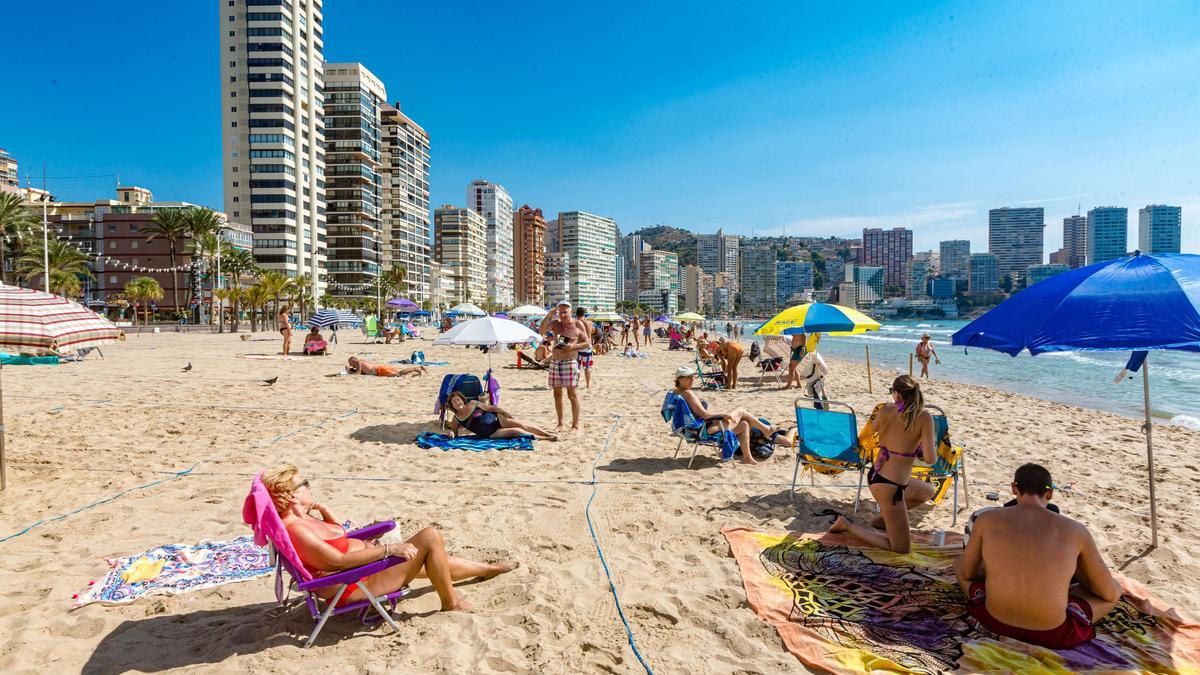 Turistas disfrutando de la playa de Levante de Benidorm este otoño.