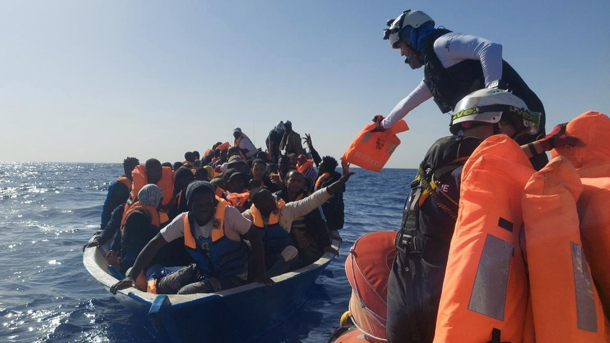 FILE PHOTO: A crew member helps migrants on a wooden boat wait to be rescued by search and rescue ship Ocean Viking, run by SOS Mediterranee, during a search and rescue (SAR) operation in the Mediterranean Sea, November 3, 2021. Picture taken November 3, 2021. Claire Juchat/SOS Mediterranee/Handout via REUTERS ATTENTION EDITORS THIS IMAGE HAS BEEN SUPPLIED BY A THIRD PARTY. NO RESALES. NO ARCHIVES/File Photo