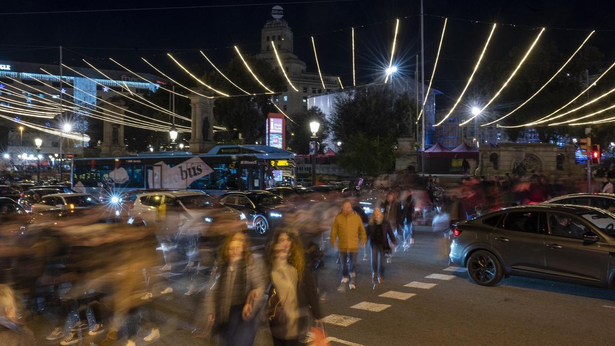 El centro de Barcelona abarrotado de gente bajo las luces de decoración de la Navidad.