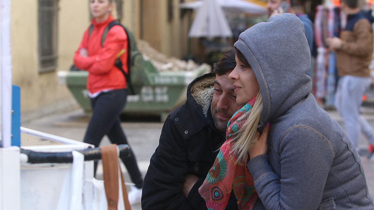 Para combatir el frío, dos personas se abrazan en el Centro de Málaga