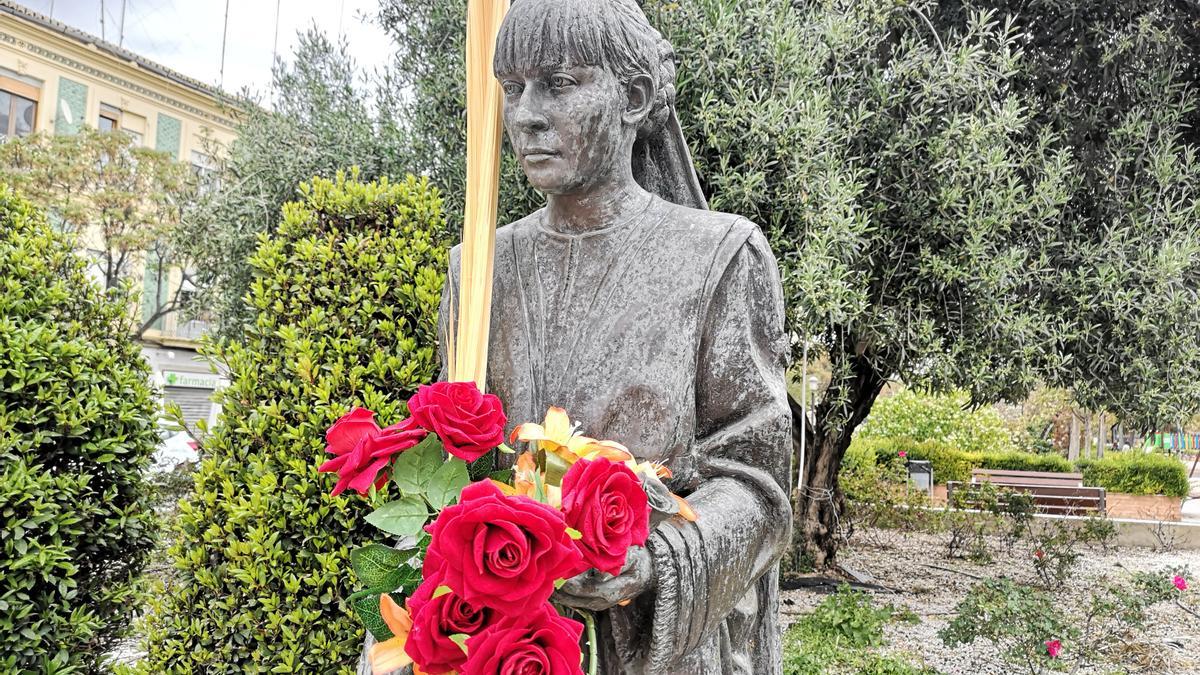 La estatua de Empar Barrón, con la palma y las flores