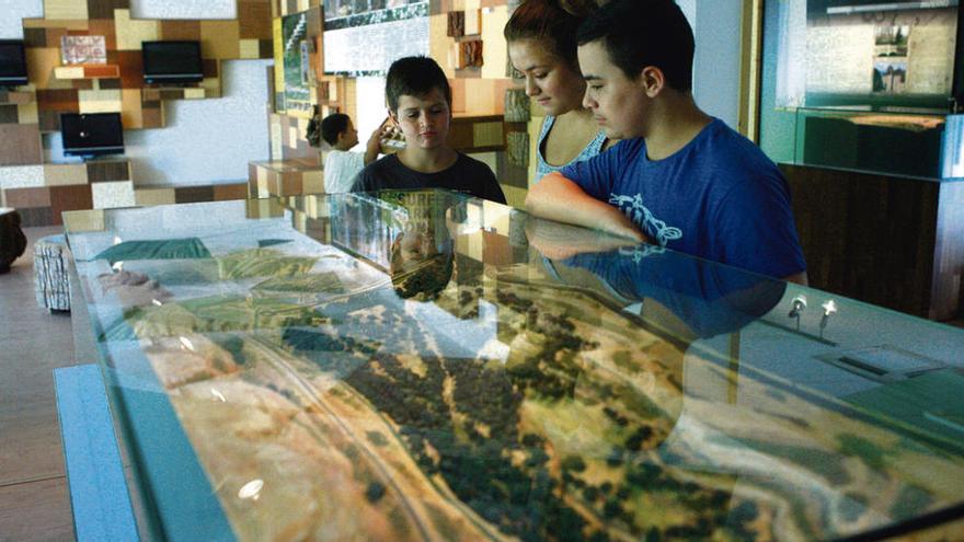 Niños del taller observan una maqueta del bosque de Valorio.