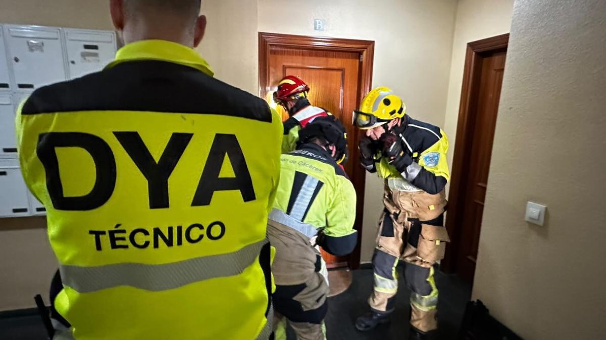 Los bomberos forzando la puerta de la vivienda de la víctima.