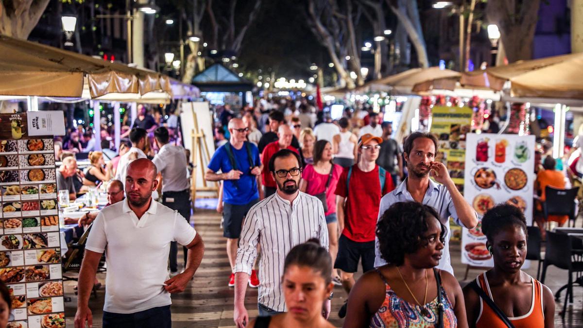 Peatones caminan entre las terrazas de la Rambla, en Barcelona.