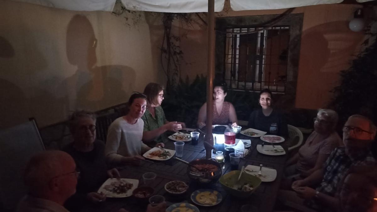 Las personas alojadas por Francisco Cortés cenan a la luz de las velas.