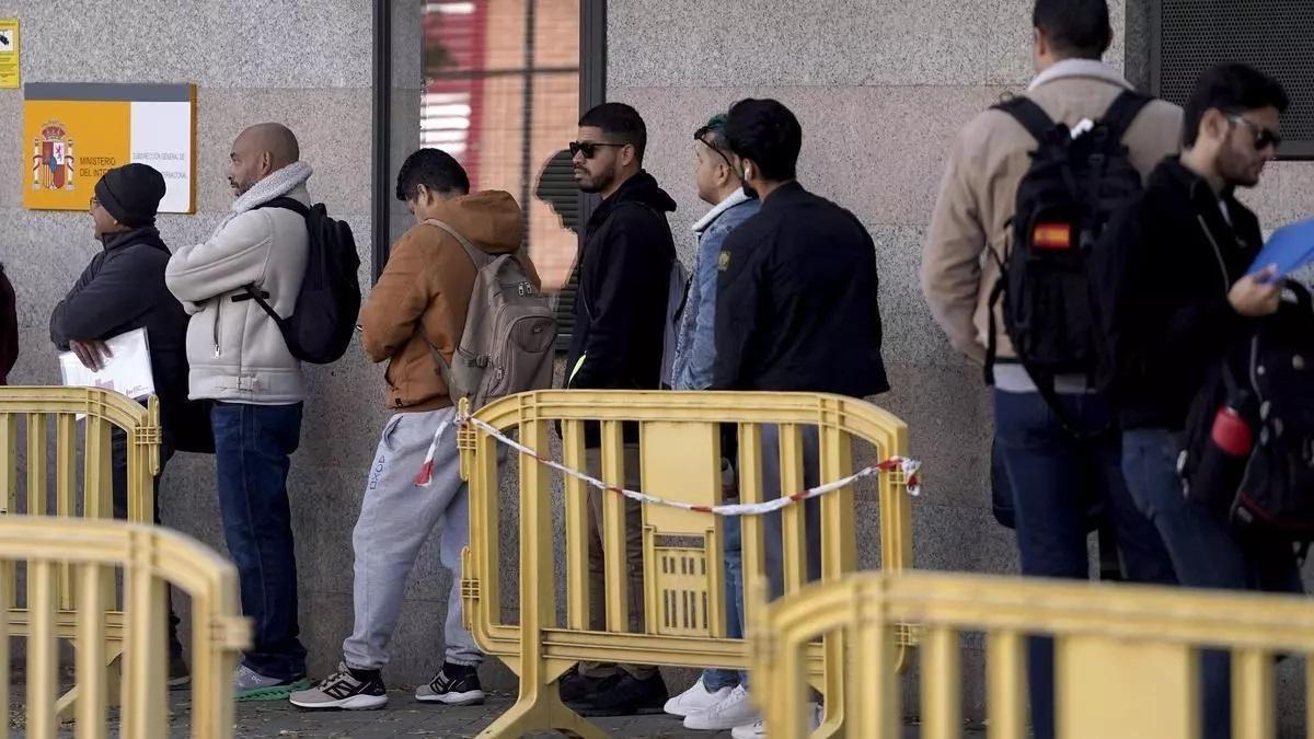 Inmigrantes guardan la cola en la Oficina de Extranjería de la ciudad de Madrid.
