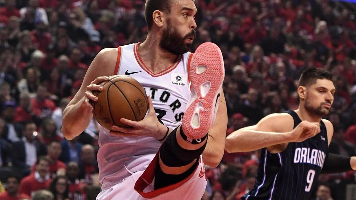 Marc Gasol captura un rebote ante Vucevic,  de los Magic