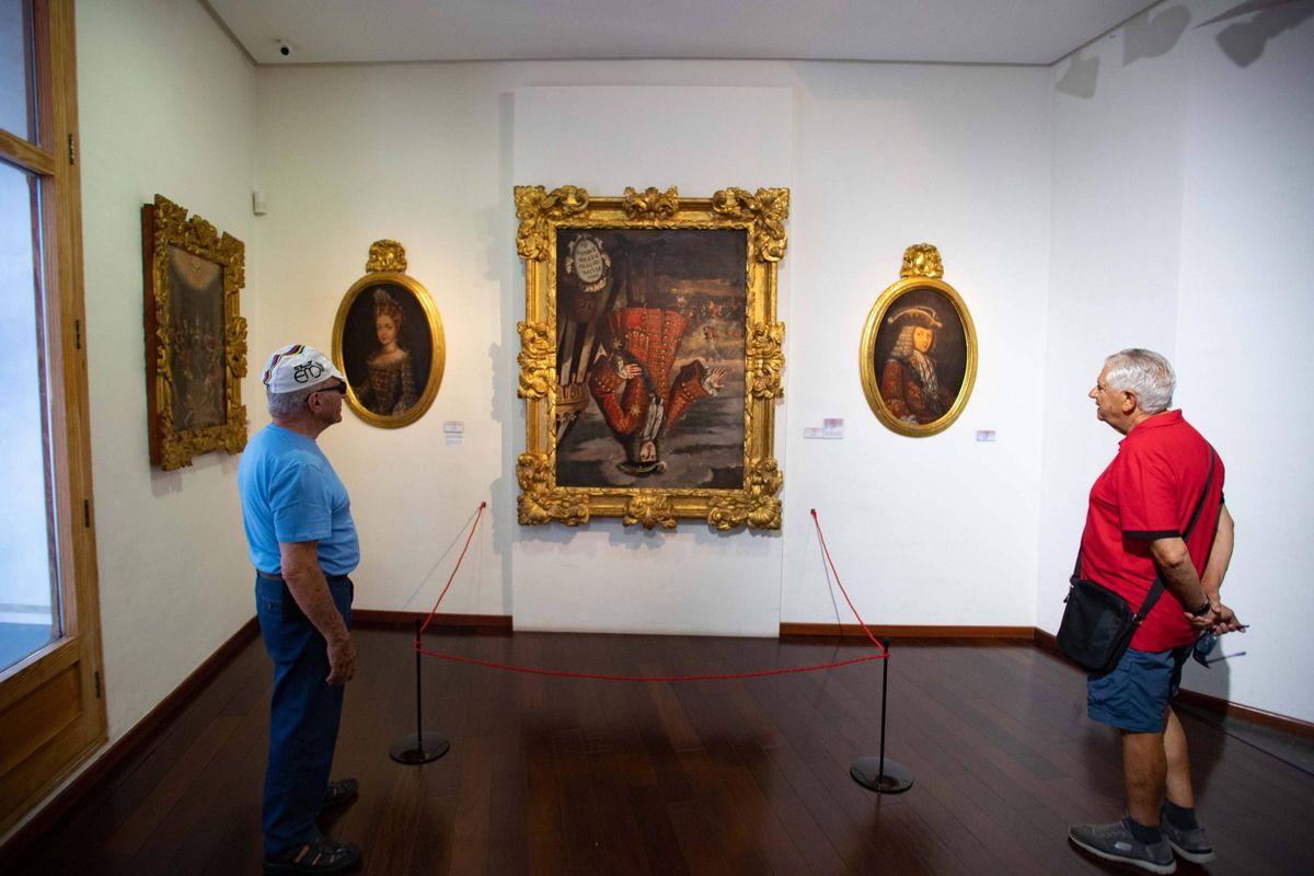 Dos visitantes de València contemplan el cuadro de Felipe V boca abajo, en el Museu de Belles Arts de Xàtiva.