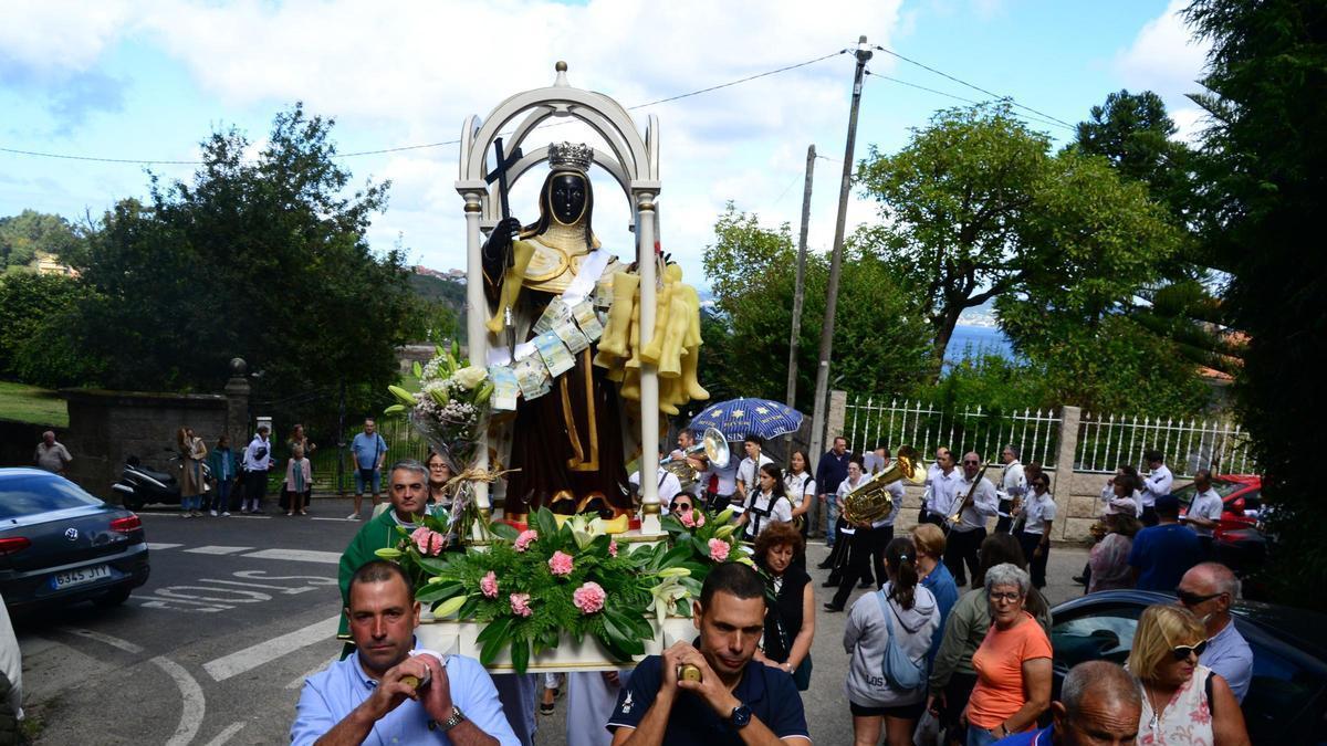 La imagen de Santa Ifigenia, en la procesión de 2025 en los alrededores del pazo de Santa Cruz (Bueu), con las ofrendas de dinero y figuras de cera. / Gonzalo Núñez
