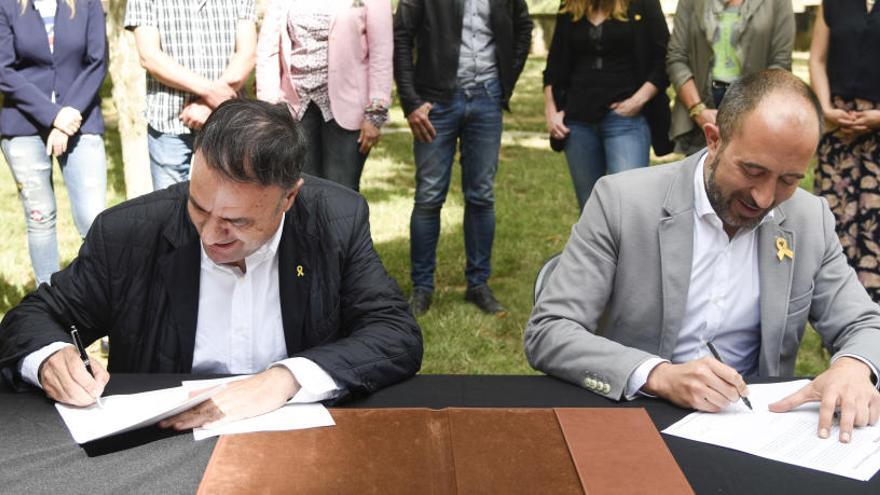 Valentí Junyent (JxManresa) i Marc Aloy (ERC) signant l&#039;acord, ahir, al parc de la Seu de Manresa