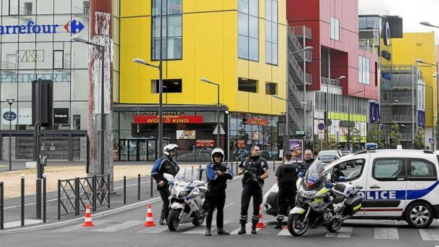 Agents de la policia participant, ahir, en les tasques de rescat dels divuit ostatges retinguts en un centre comercial