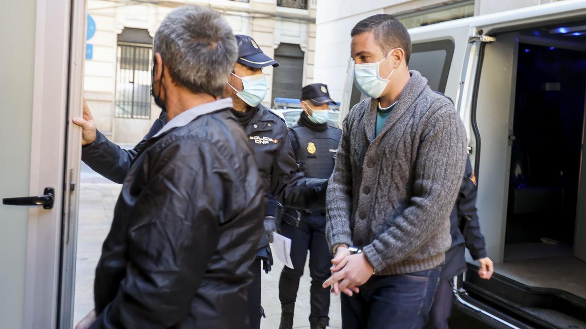 El condenado por matar a su madre, a la derecha al llegar al juicio en la Audiencia de Alicante.