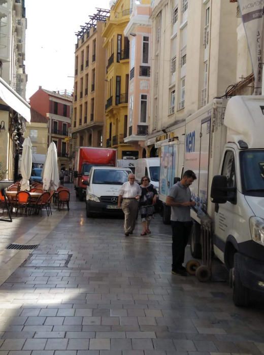 La calle Granada, ocupada por camiones de descarga de mercancías.