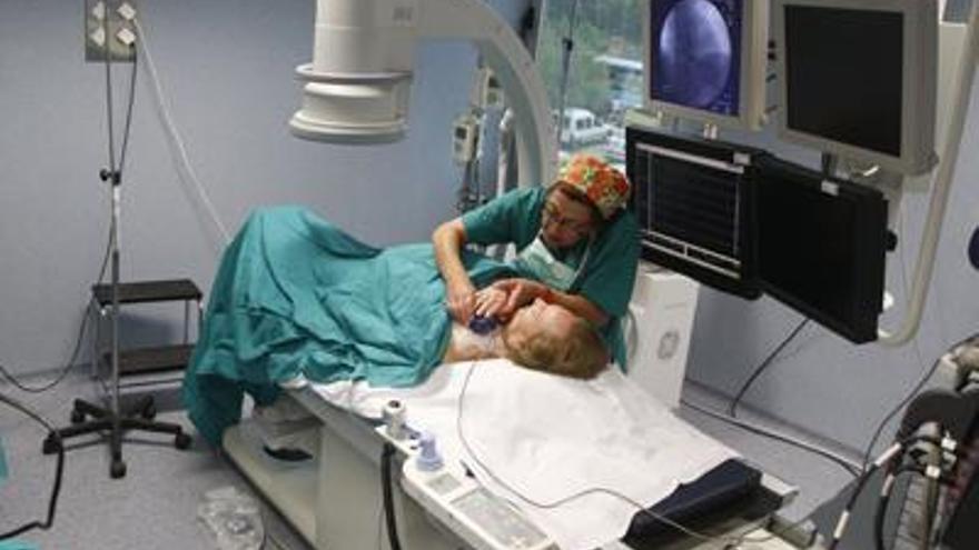 Unidad de arritmias. Una paciente en la consulta del Clínico se pone el dispositivo en el pecho para controlar sus constantes.