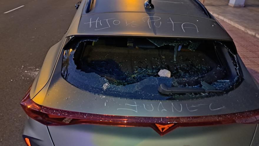 Un hombre rompe el cristal de un coche con una piedra